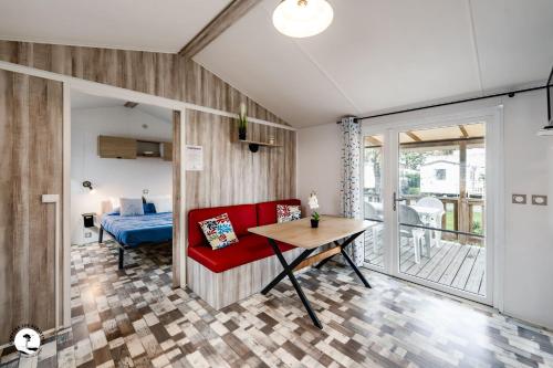 un salon avec un canapé rouge et une table dans l'établissement Camping Les Violettes, à La Faute-sur-Mer