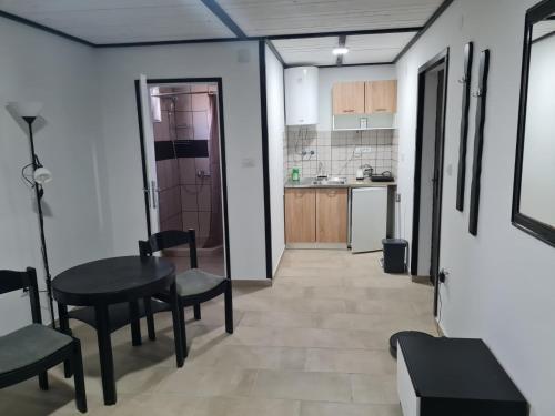 ein Zimmer mit Tisch und Stühlen und eine Küche in der Unterkunft Gabriela in Sremska Mitrovica