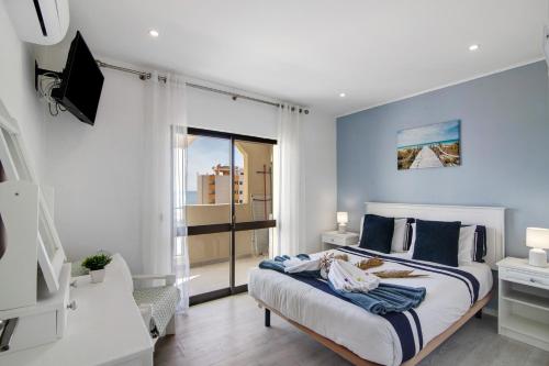 um quarto com uma cama com paredes azuis e uma janela em Luxury Beach View - Praia da Rocha em Portimão