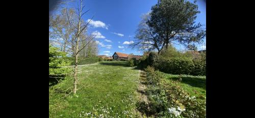 a field of grass with a house in the background at B&B - Villa des Remparts - Ardres proche Calais-St Omer-Dunkerque in Ardres