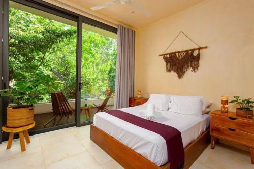 um quarto com uma cama e uma grande janela em * Dream Villa on Private Cenote 10min to Beach em Akumal