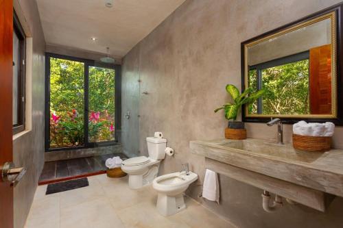 * Dream Villa on Private Cenote 10min to Beach في أكومال: حمام مع مرحاضين ومغسلة ومرآة