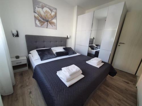 een slaapkamer met een groot bed en handdoeken bij Apartman Sunce in Kaštela