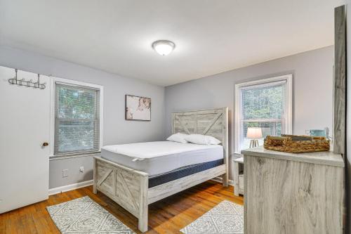 a bedroom with a bed and two windows at Raleigh Retreat about 5 Mi to Dtwn and Historic Oakwood! in Raleigh