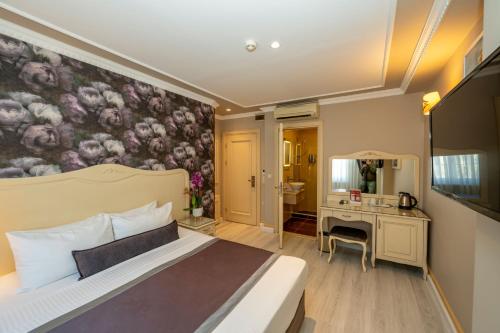 イスタンブールにあるレイモンド ホテルのベッドルーム1室(壁に絵画が描かれたベッド1台付)