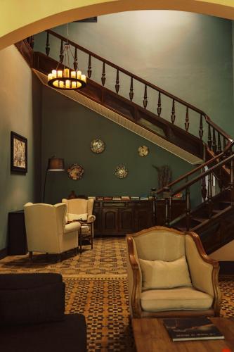 a living room with two chairs and a staircase at Roça Sundy - Principe Collection in Santo António