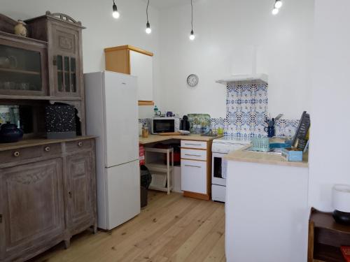 a kitchen with a white refrigerator and a sink at Pyrenees Vue - Vues Fantastique, Calme, Jardin, Piscine, Parking Gratuit Sur Place in Saint-Gaudens