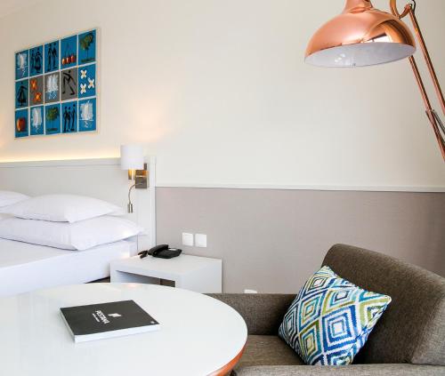 a room with a couch and a table and a bed at Hotel Pestana Cascais Ocean & Conference Aparthotel in Cascais