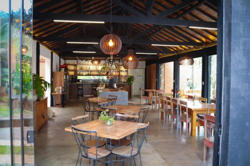 a restaurant with wooden tables and chairs and a bar at Pousada Vidinha Bela in Brazópolis