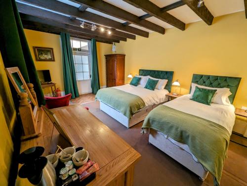 ein Schlafzimmer mit 2 Betten und einem Tisch mit Schuhen in der Unterkunft Archway House in Grantham