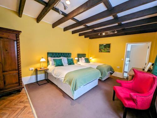 a bedroom with a large bed and a red chair at Archway House in Grantham