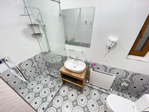 une salle de bain avec un lavabo et une douche dans l'établissement Meros Hotel, à Boukhara
