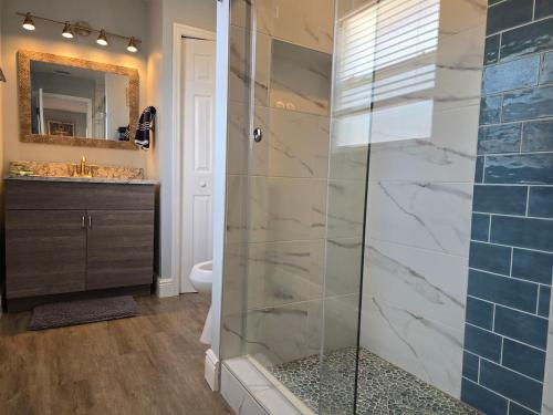 a bathroom with a shower with a glass door at Redfish - Updated & Roomy 1.5 Mi to Beach Full Kitchen W&D in Bonita Springs