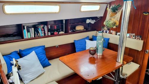 a table in the back of a boat with blue pillows at Velero en Isla Linton in Puerto Lindo