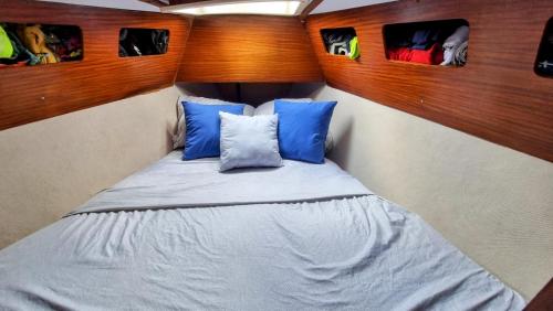 niewielka sypialnia z łóżkiem z niebieskimi poduszkami w obiekcie Velero en Isla Linton w mieście Puerto Lindo