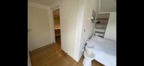 a small white bedroom with a bed and a hallway at B&B - Villa des Remparts - Ardres proche Calais-St Omer-Dunkerque in Ardres