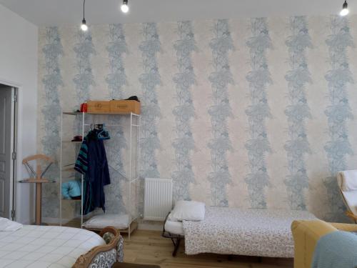 a bedroom with a bed and a wall with wallpaper at Pyrenees Vue Gite - Vues Fantastique, Parking Gratuit Sur Place & Piscine in Saint-Gaudens