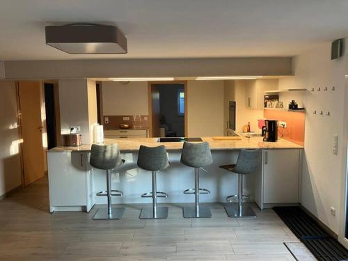 a kitchen with four stools at a kitchen counter at Romantikurlaub im Weindorf Kiedrich in Kiedrich