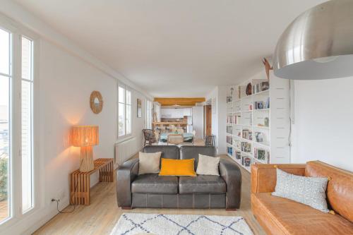 un salon avec un canapé et une chaise dans l'établissement Charmant et Chaleureux avec garage privé, à Villeurbanne