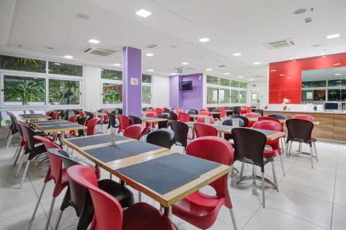a dining room with tables and red chairs at Transamerica Fit Campinas in Campinas