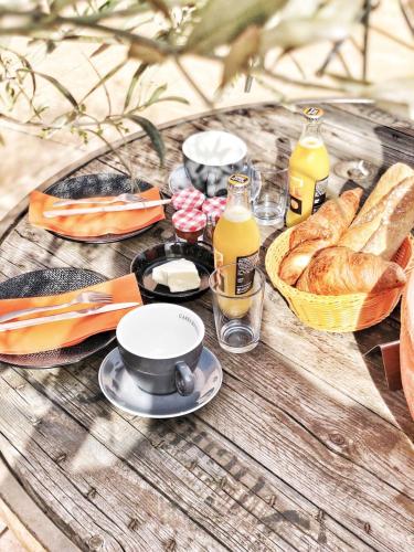 a table with bread and drinks and a basket of food at Hôtel Ô9 marches in Rillieux