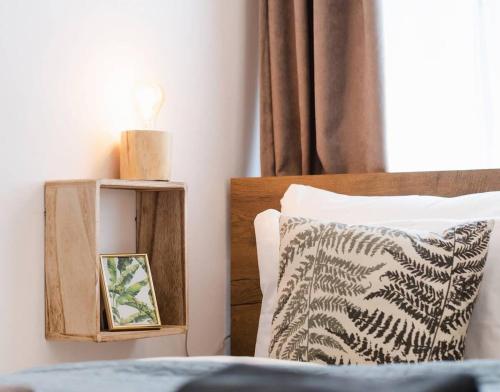 a bedroom with a bed and a nightstand with a pillow and a window at Perfect place in the heart of downtown in Budapest