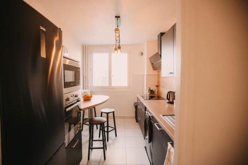a kitchen with a black refrigerator and a counter at Centre & Campus, 6p, 3 ch, 2 sdb, Parking in Besançon