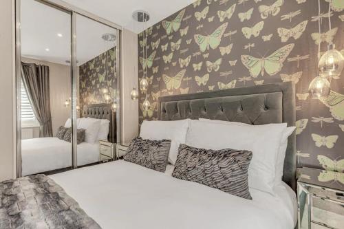 a bedroom with a bed with butterflies on the wall at Foxglove House in Loughborough