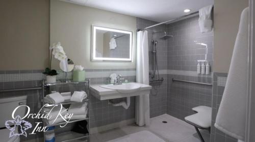 a bathroom with a sink and a shower at Orchid Key Inn - Adults Only in Key West