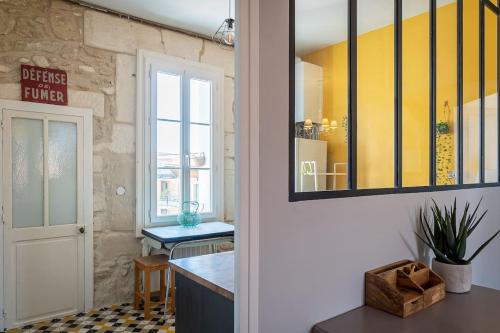 eine Küche mit einer Theke und einer gelben Wand in der Unterkunft L'Atelier Pop, Beau T3, Quartier des Beaux Arts in Montpellier