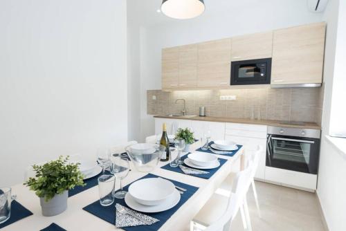 een witte keuken met een eettafel met witte stoelen bij Trendy central apartment at Castle in Boedapest