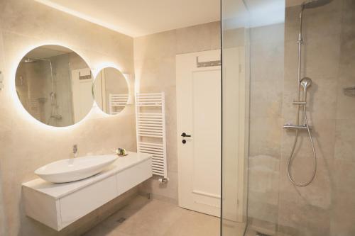a white bathroom with a sink and a shower at Hotel Bernarda in Varaždinske Toplice