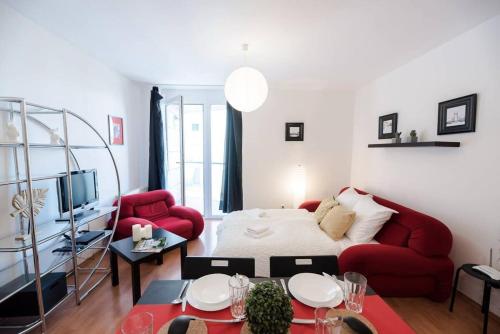 a living room with a red couch and a red chair at Bright and homey AC apartment near the center in Budapest