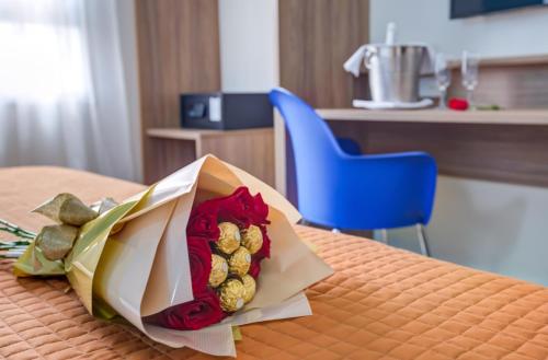 a bouquet of roses on a table with a blue chair at Transamerica Fit Campinas in Campinas