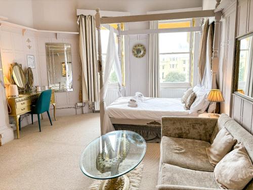 a living room with a bed and a glass table at X Hotel Brunswick Square in Brighton & Hove