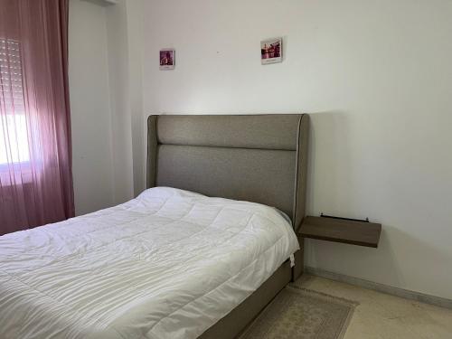 a small bedroom with a bed and a window at Residence Ahlem in El Aouina
