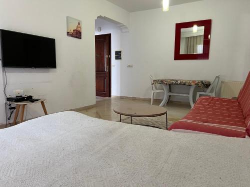 a bedroom with a bed and a tv and a couch at Residence Ahlem in El Aouina