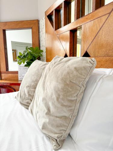 a pillow sitting on a bed with a wooden headboard at X Hotel Brunswick Square in Brighton & Hove