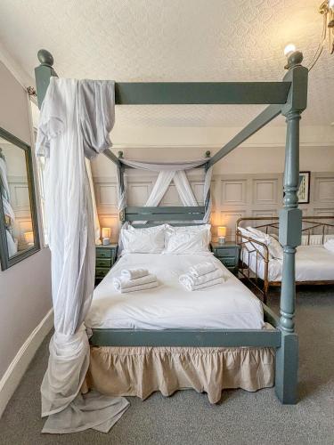 a bedroom with a canopy bed with white sheets at X Hotel Brunswick Square in Brighton & Hove