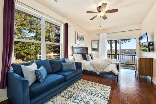 een woonkamer met een blauwe bank en een bed bij Birds Eye Retreat-10 acres on Beaver Lake-Hot Tub in Rogers