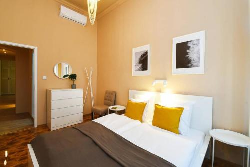 a bedroom with a white bed with yellow pillows at Very central very spacious new home in Budapest