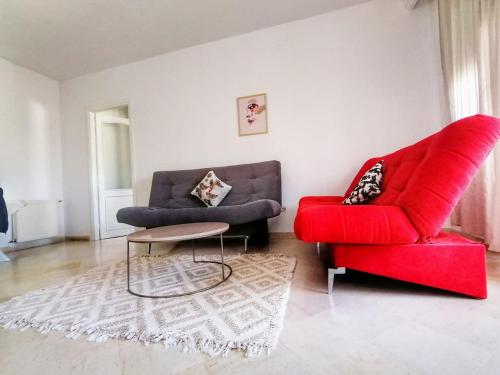 a living room with a red couch and a red chair at Residence Ahlem in El Aouina