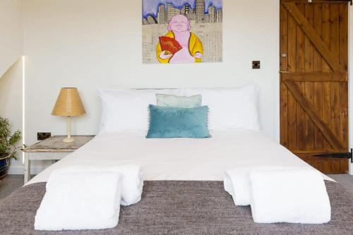 a bedroom with a white bed with a wooden door at Hygge House Cosy 3 Bedroom 2 Bathroom Townhouse in Kegworth
