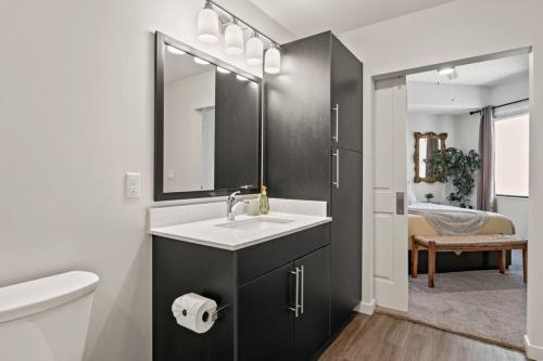 a bathroom with a sink and a toilet and a mirror at Stylish Urban Retreat Steps from Lake Eola in Orlando