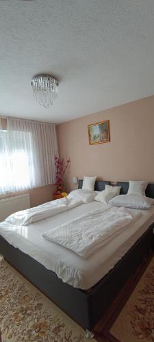 a large bed in a bedroom with a chandelier at Apartment Deluxe Holiday in Bihać