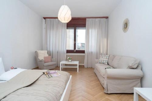 ein Wohnzimmer mit einem Bett, einem Sofa und einem Stuhl in der Unterkunft Convenient apartment in the heart of downtown in Budapest