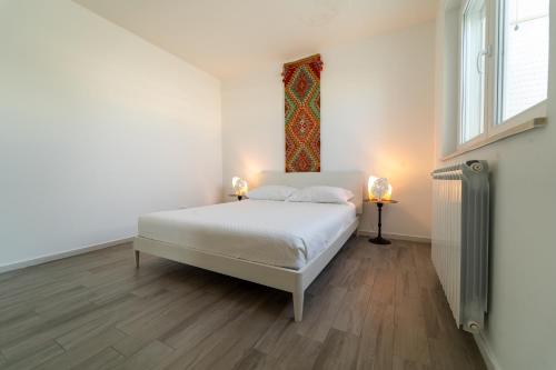 a white bedroom with a bed and a window at Fronte mare in Polignano a Mare
