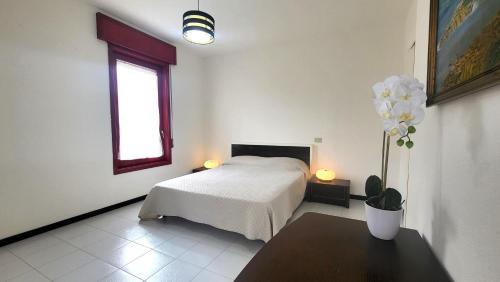 una camera con letto, tavolo e finestra di Villa Isola Bella - Appartamento Bianconero a Mògoro