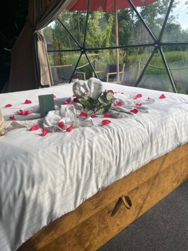 Una cama con rosas rojas y animales de peluche. en Back to Nature en Boelenslaan