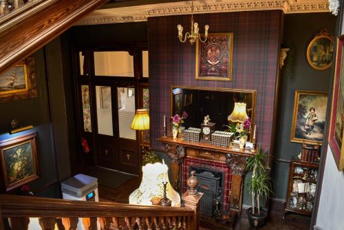 a living room with a fireplace and a mirror at Heatherlie House Hotel in Selkirk